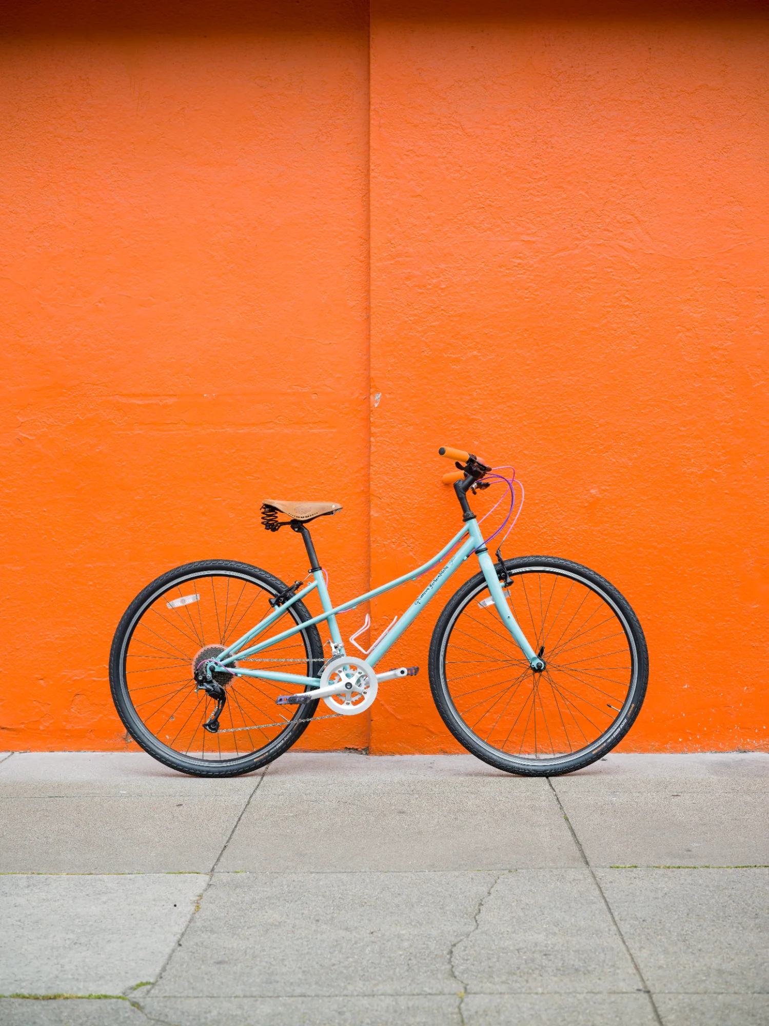 Mint bike against orange wall